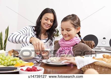 Stock Photo - Mother and daughter eating breakfast. Fotosearch