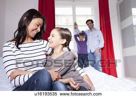 Stock Photography - Mother and daughter hugging on bed. Fotosearch