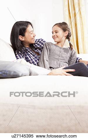 Mother and daughter relaxing on sofa View Large Photo Image Stock Photography - Mother and daughter relaxing on sofa. Fotosearch
