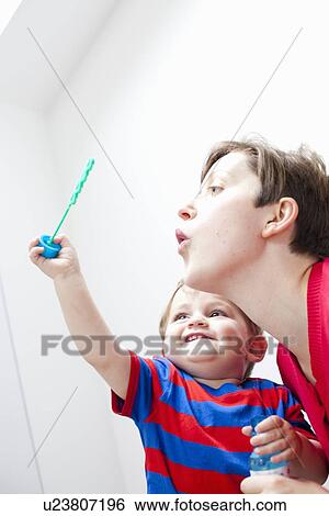 Mother and son blowing bubbles together View Large Photo Image Stock Photograph - Mother and son blowing bubbles together. Fotosearch