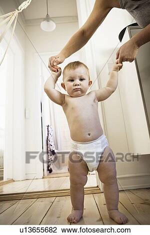 Mother helping baby girl walk View Large Photo Image Stock Image - Mother helping baby girl walk. Fotosearch