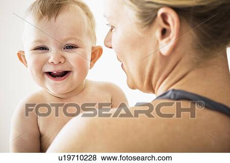 Mother holding smiling baby girl View Large Photo Image Stock Photo - Mother holding smiling baby girl. Fotosearch