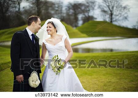 Newlywed couple holding hands outdoors View Large Photo Image Stock Image - Newlywed couple holding hands outdoors. Fotosearch