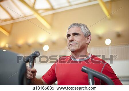 Stock Photography - Older man using treadmill in gym. Fotosearch