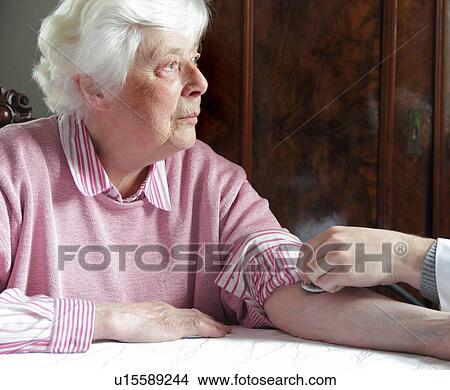 Picture - Older woman having pulse checked. Fotosearch