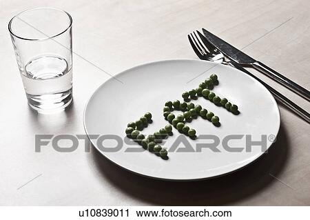 Stock Image - Peas arranged to spell fat on plate. Fotosearch