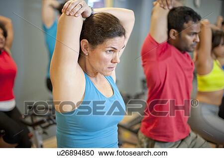Stock Image - People stretching on spin machines. Fotosearch