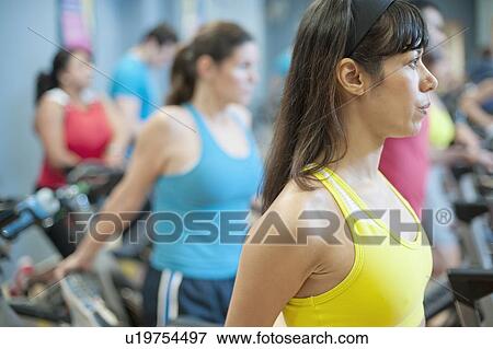 Stock Photo - People stretching on spin machines. Fotosearch