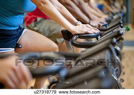 Stock Photo - People using spin machines in gym. Fotosearch