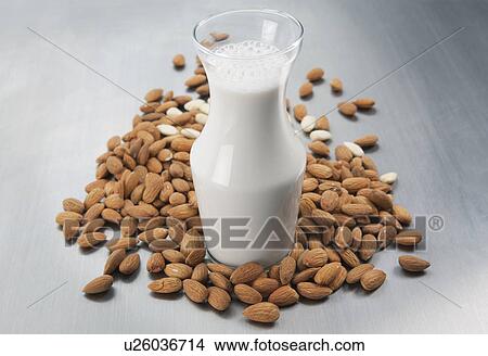 Picture - Pitcher of almond milk and raw almonds. Fotosearch