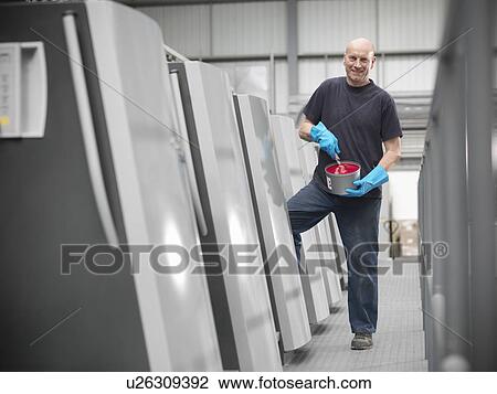 Stock Image - Printer mixing red ink at press. Fotosearch