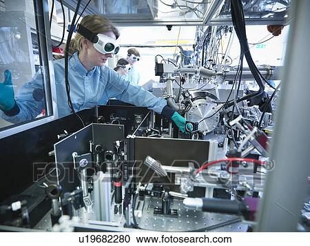 Stock Image - Scientist adjusting a mirror in lab. Fotosearch