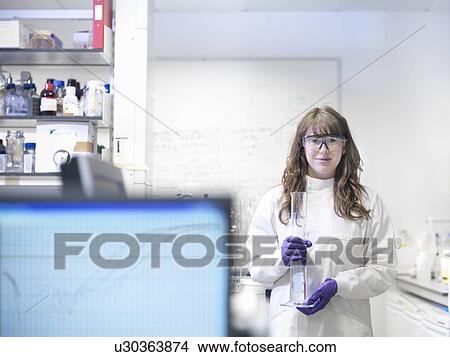 Scientist carrying beaker in lab View Large Photo Image Picture - Scientist carrying beaker in lab. Fotosearch