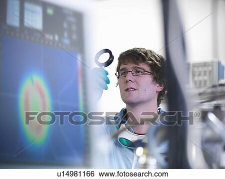 Scientist examining lens in lab View Large Photo Image Stock Photograph - Scientist examining lens in lab. Fotosearch