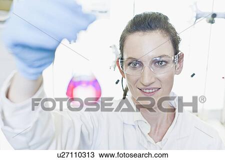 Stock Image - Scientist examining liquid in lab. Fotosearch