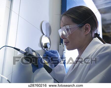 Scientist gauging window in lab View Large Photo Image Stock Photograph - Scientist gauging window in lab. Fotosearch