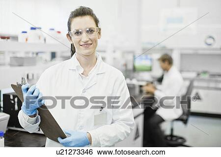 Scientist holding clipboard in lab View Large Photo Image Stock Photograph - Scientist holding clipboard in lab. Fotosearch