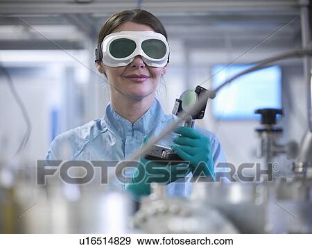 Stock Photo - Scientist holding laser mirror in lab. Fotosearch