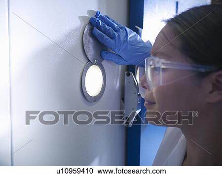 Scientist looking through window in lab View Large Photo Image Stock Image - Scientist looking through window in lab. Fotosearch