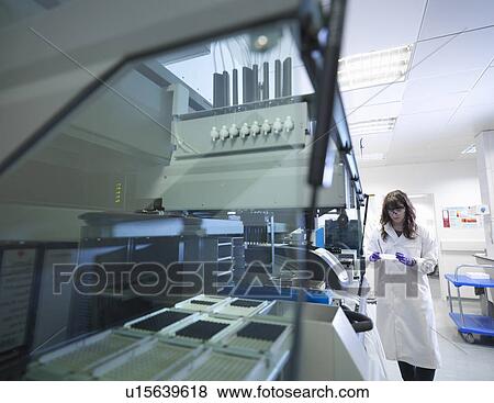 Stock Photo - Scientist using equipment in lab. Fotosearch