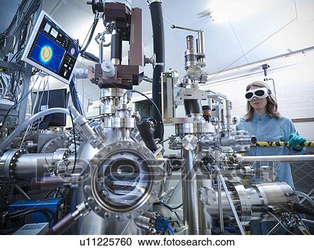 Stock Image - Scientist using vacuum chamber in lab. Fotosearch