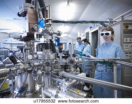 Stock Image - Scientist using vacuum chamber in lab. Fotosearch