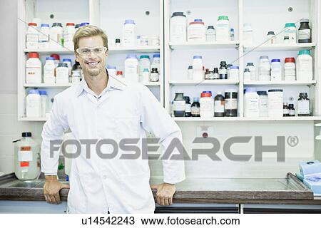 Stock Image - Scientist wearing goggles in lab. Fotosearch