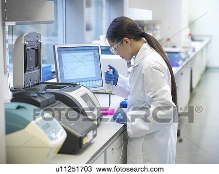 Scientists piping liquid into tubes View Large Photo Image Stock Image - Scientists piping liquid into tubes. Fotosearch