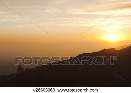 Stock Image - Silhouette of hillside at sunset. Fotosearch