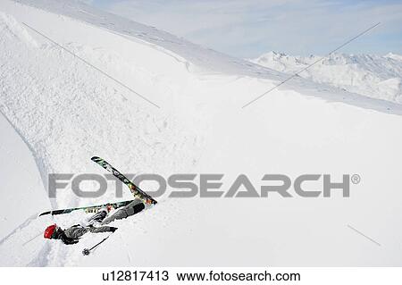 Stock Image - Skier doing flip on snowy slope. Fotosearch