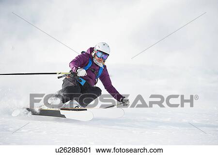 Stock Image - Skier skiing on snowy slope. Fotosearch