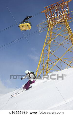 Stock Photo - Skier skiing on snowy slope. Fotosearch