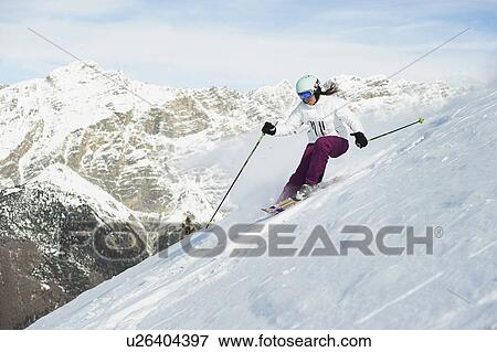 Stock Photo - Skier skiing on snowy slope. Fotosearch