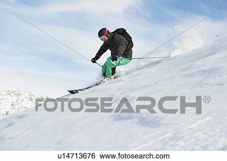 Stock Photograph - Skier skiing on snowy slope. Fotosearch
