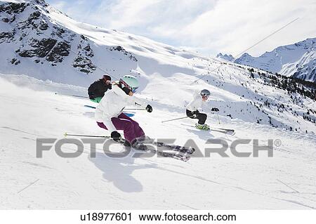 Stock Image - Skiers skiing together on slope. Fotosearch