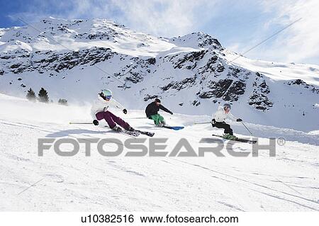 Skiers skiing together on slope View Large Photo Image Stock Photograph - Skiers skiing together on slope. Fotosearch
