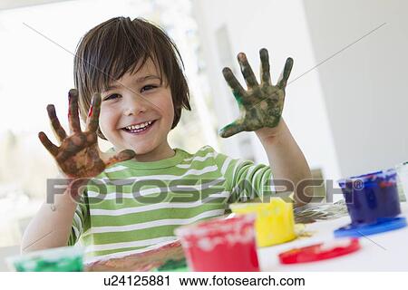 Smiling boy finger painting indoors View Large Photo Image Stock Image - Smiling boy finger painting indoors. Fotosearch