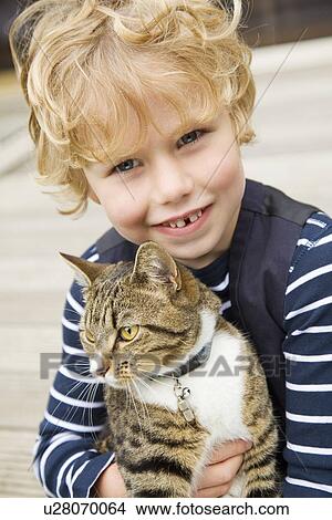 Smiling boy holding cat outdoors View Large Photo Image Picture - Smiling boy holding cat outdoors. Fotosearch