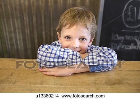 Picture - Smiling boy leaning on counter. Fotosearch