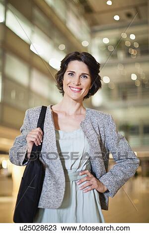 Stock Image - Smiling businesswoman with briefcase. Fotosearch