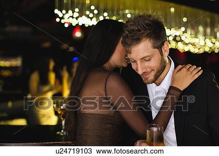 Smiling couple whispering at bar View Large Photo Image Stock Image - Smiling couple whispering at bar. Fotosearch