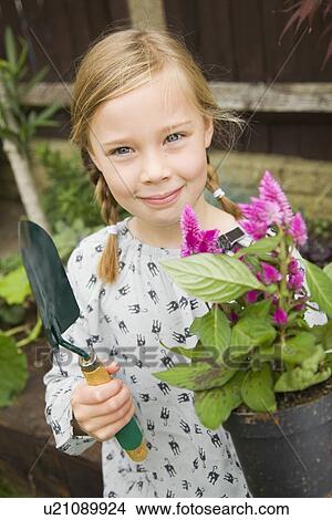 Smiling girl planting flowers outdoors View Large Photo Image Picture - Smiling girl planting flowers outdoors. Fotosearch