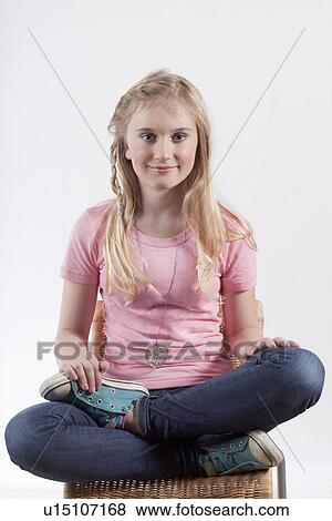 Smiling girl sitting cross legged View Large Photo Image Stock Photo - Smiling girl sitting cross legged. Fotosearch