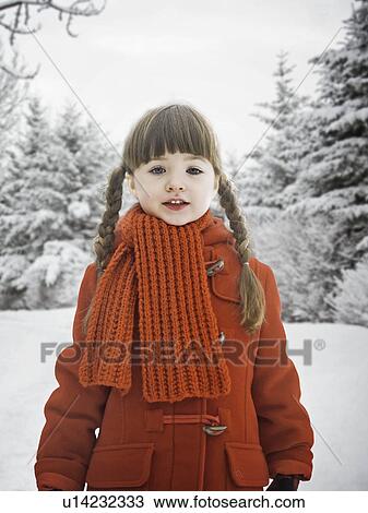 Stock Image - Smiling girl standing in snow. Fotosearch