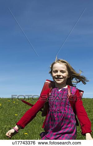 Smiling girl wearing backpack outdoors View Large Photo Image Stock Photograph - Smiling girl wearing backpack outdoors. Fotosearch
