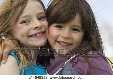 Smiling girls hugging outdoors View Large Photo Image Stock Photo - Smiling girls hugging outdoors. Fotosearch