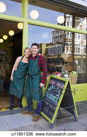 Smiling grocers standing outside store View Large Photo Image Stock Photograph - Smiling grocers standing outside store. Fotosearch