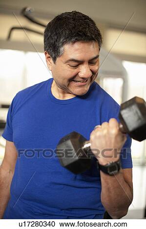 Smiling man lifting weights in gym View Large Photo Image Stock Image - Smiling man lifting weights in gym. Fotosearch