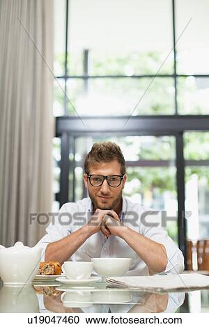 Smiling man sitting at breakfast View Large Photo Image Stock Image - Smiling man sitting at breakfast. Fotosearch