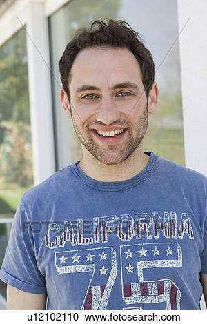 Stock Image - Smiling man standing outdoors. Fotosearch